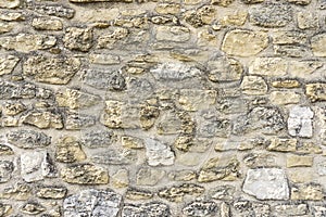 Rough surface of random pattern rastic of brown and light yellow color natural free form sand stone cladding on the concrete wall photo
