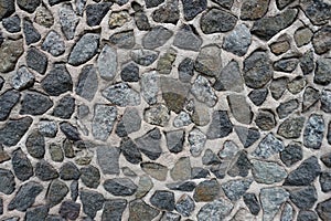 Rough surface of wall with dark gray gravel pebbledash