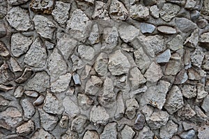 Rough surface of wall with light gray gravel pebble dash