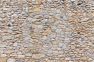 Rough textured old stone block wall