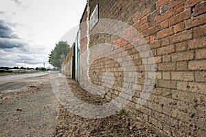 Rough textured surface of a weathered brick wall at a livery yard.