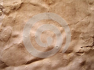 Rough uneven terracotta colored cement wall background with paint brush marks texture