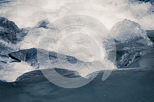 Rough water flows through the stones. Waterfall.