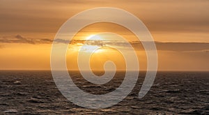 Rough weather off the lighthouse at sunset Isle of Anglesey North Wales