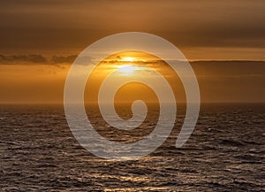 Rough weather off the lighthouse at sunset Isle of Anglesey North Wales