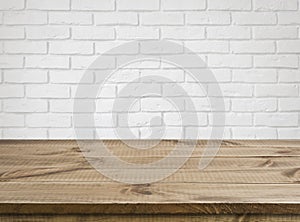 Rough wooden texture table over defocused white brick wall background