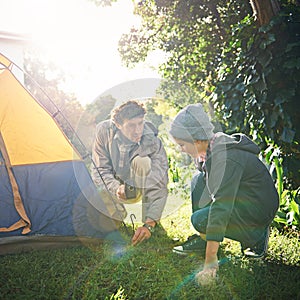 Roughing it in the wild with his lil dude. a father and his young son putting up their tent.