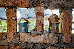 Roughly built brick wall inset with childrens painted houses