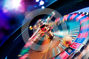 Roulette wheel in motion with a bright and colorful background