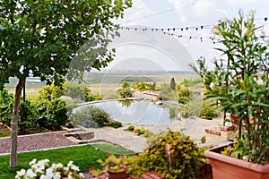 Round artificial pond with fish in the garden of a country house.