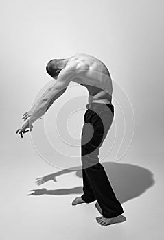 Round back. Black and white photography. Masculinity aesthetics. Young man posing shirtless. Muscular body shape
