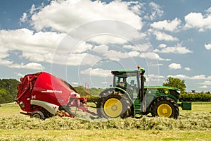 A round baler discharges a hay bale during harvesting