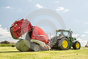 A round baler discharges a hay bale during harvesting