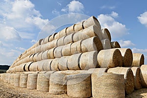 Round bales of straw straightened into a pyramid shape.