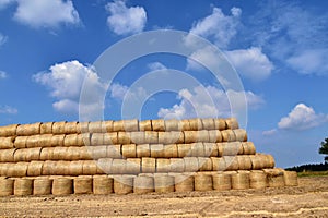 Round bales of straw straightened into a pyramid shape.