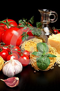 Round balls of pasta with cheese, tomatoes,basil,olive oil on black