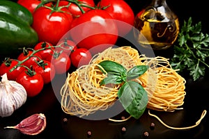 Round balls of pasta with tomatoes,basil,olive oil on black