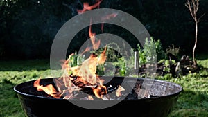 Round barbecue with burning firewood. Grill preparation