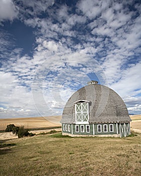 Round barn against a blue sky.