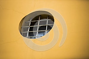 Round barred window in the wall of