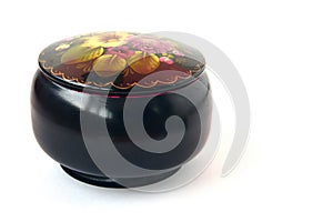 Round black casket with a pattern of flowers on a white background