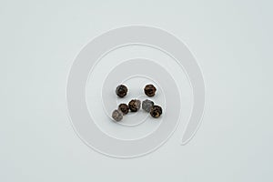 The round black pepper is arranged in the shape of a smiley face