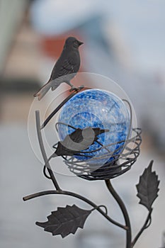 Round blue globe and metal bird