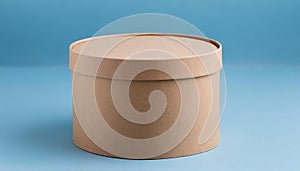 Round brown cardboard box on blue background. Mock up. Packaging for delivery. Eco package