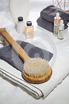 Round brush with a long handle for dry massage. Various spa objects on white background. photo