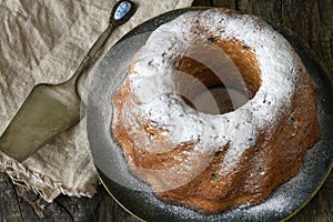 Round bundt cake with raisins, sprinkled with powdered sugar. Close up.
