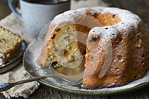 Round bundt cake with raisins, sprinkled with powdered sugar. Close up.