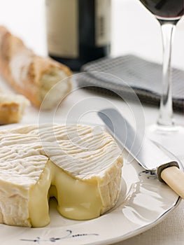 Round of camembert cheese with French stick photo