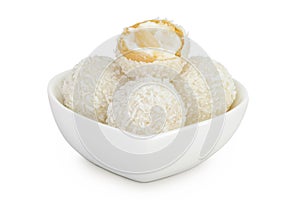round candy raffaello with coconut flakes and nut in ceramic bowl isolated on white background photo