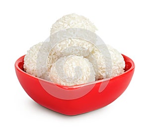 round candy raffaello with coconut flakes and nut in ceramic bowl isolated on white background
