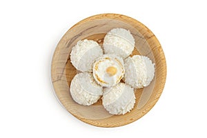 round candy raffaello with coconut flakes and nut in wooden bowl isolated on white background