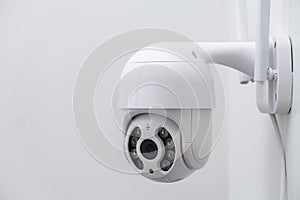 Round CCTV camera with antennas shoots video on the white wall