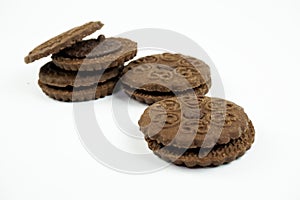 Round chocolate biscuits scattered on a white background