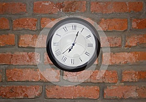 Round clock on a brick wall background
