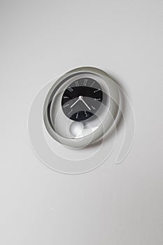 Round clock with a pendulum on a white background