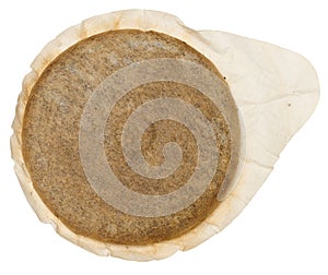 A round coffee pod or single serving of ground coffee wrapped in filter paper