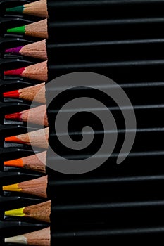Round colored pencils with black bodies and colored tips ordered in their box