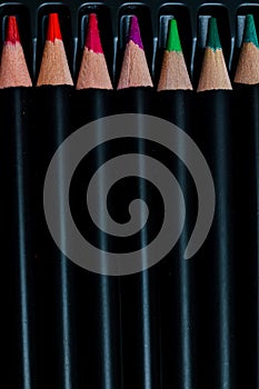 Round colored pencils with black bodies and colored tips ordered in their box