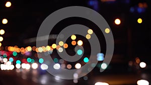 Round colorful bokeh shine from car lights in traffic jam on city street. Beautiful glittering bokeh in dark blurry