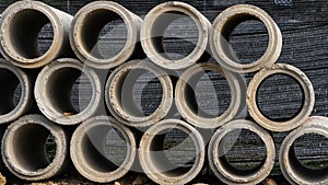 Round concrete culverts made of high-grade reinforced concrete at the construction site lay a lot of spoons on the ground.