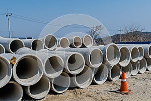 Round concrete culverts stacked in countryside