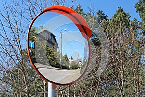 A round convex mirror is installed at the village crossroads for photo