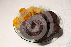 Round cookies in chocolate with cinnamon and candied pineapple