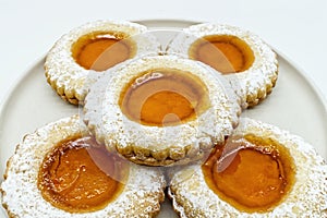 Round cookies with fruit jam and icing sugar, italian occhi di bue,  on white photo