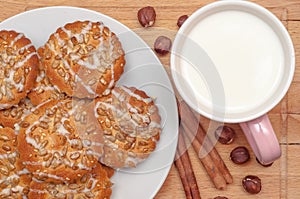 Round cookies with sunflower and sesame seeds, milk in pink mug, top view. Valuable breakfeast.