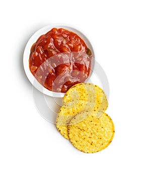 Round corn nacho chips and tomato dip. Yellow tortilla chips and salsa